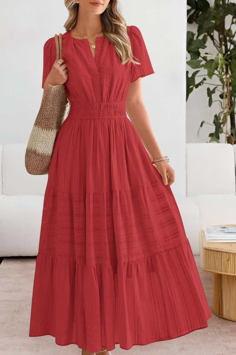 Woman wearing an airy boho maxi dress styled for warm weather on a plain background.