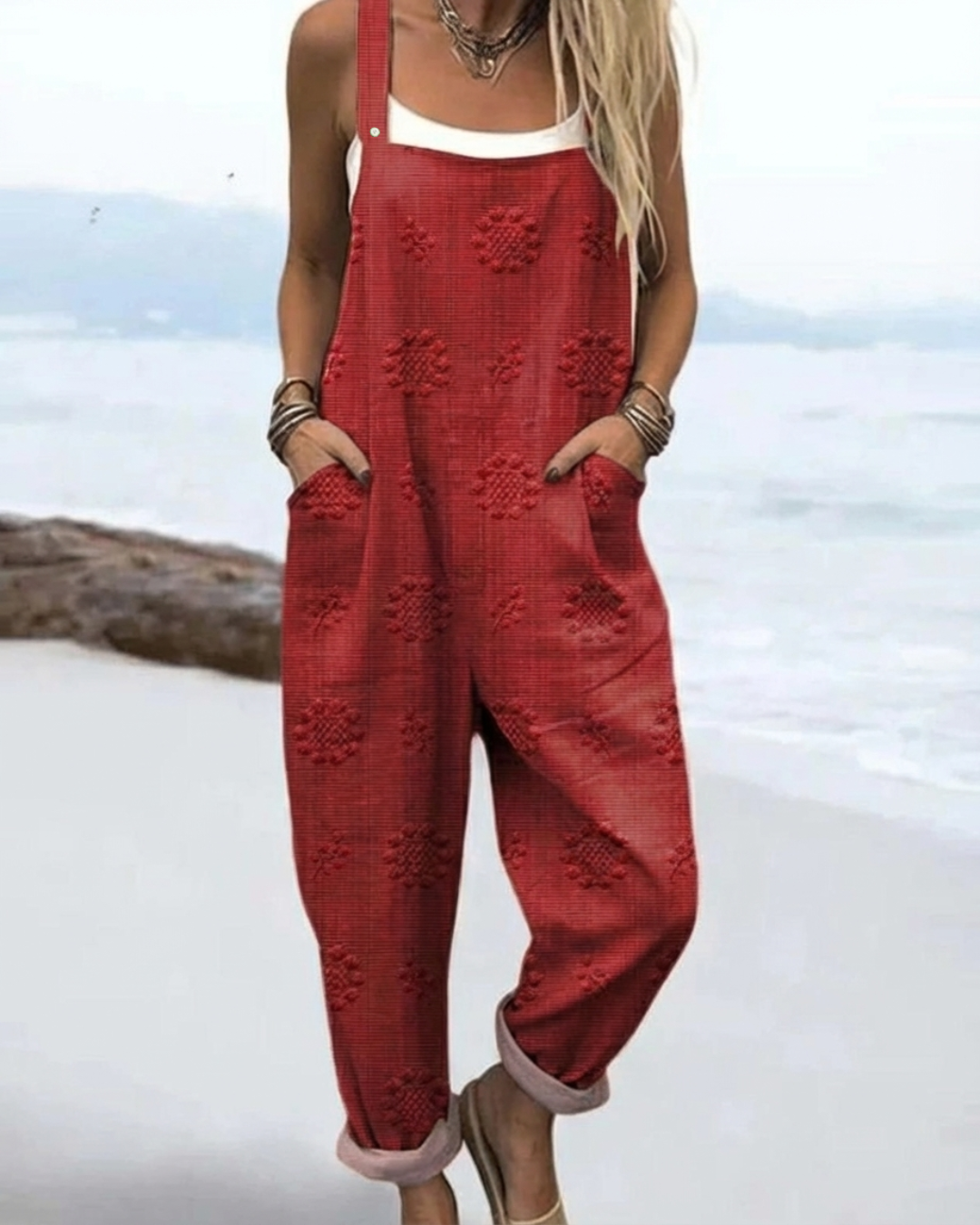 Female model wearing a floral sleeveless jumpsuit against a plain background.