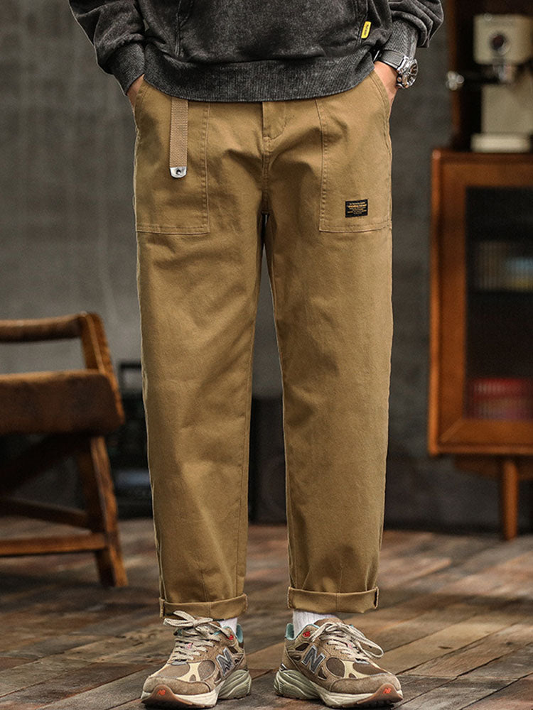  Male model wearing modern cargo trousers with a relaxed silhouette on a plain background.