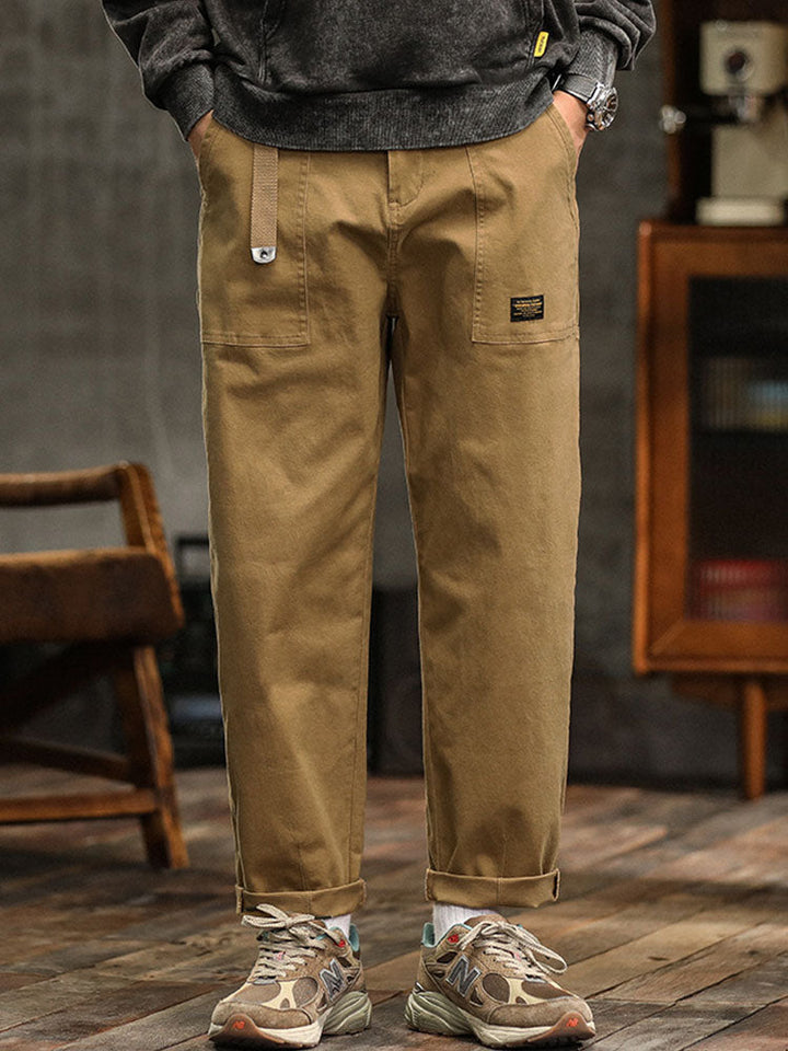  Male model wearing modern cargo trousers with a relaxed silhouette on a plain background.