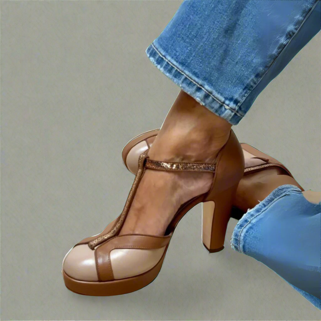 Foot wearing elegant heeled sandal on a plain background.
