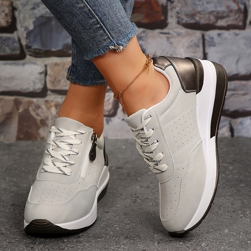 Female wearing low-top walking shoes with a clean plain backdrop.