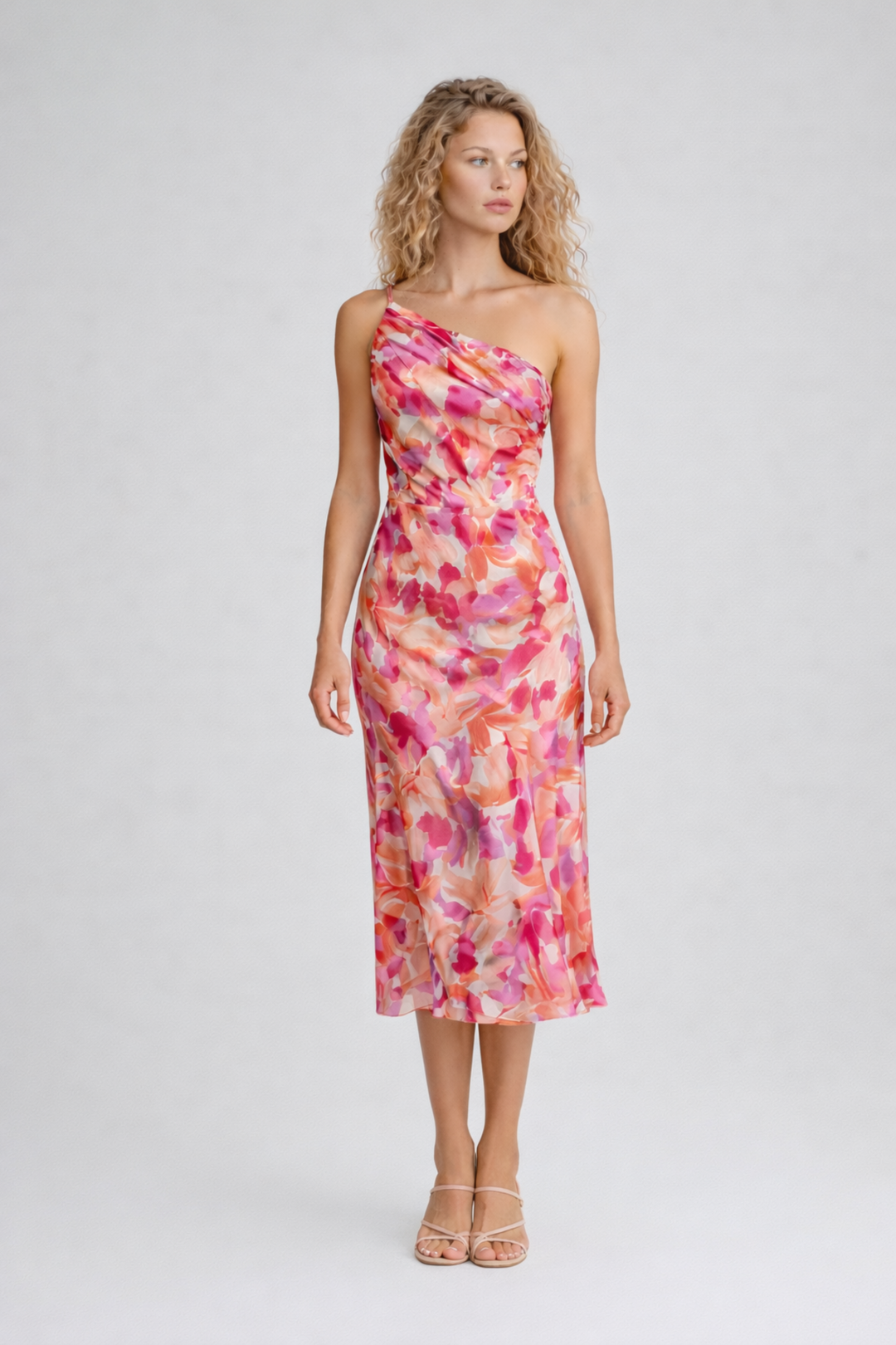 Woman wearing a floral one-shoulder midi dress on a plain background.