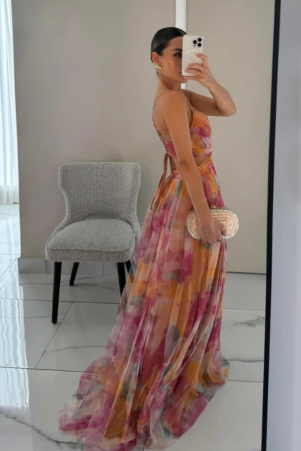 Woman in a refined flowing dress against a simple background.