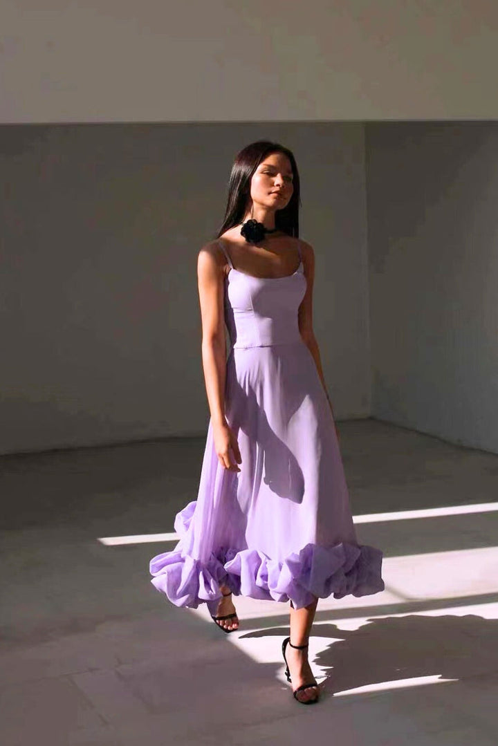 Woman modeling a flowing silhouette dress on a clean background.