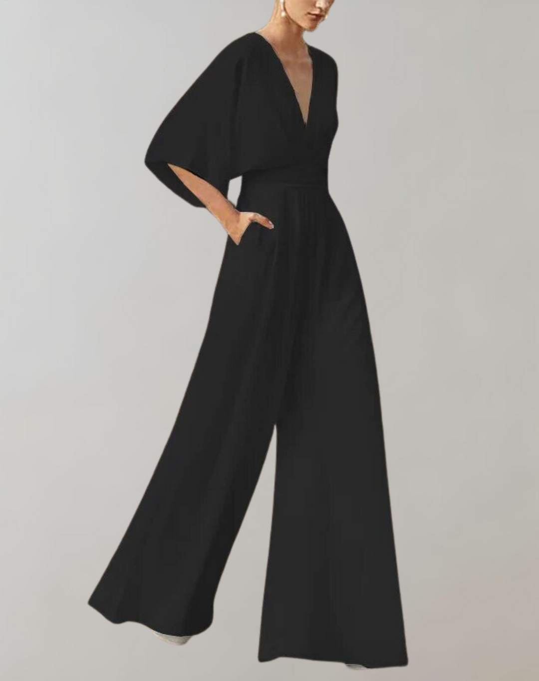 Flowing women’s evening jumpsuit with a flattering silhouette on a plain backdrop.