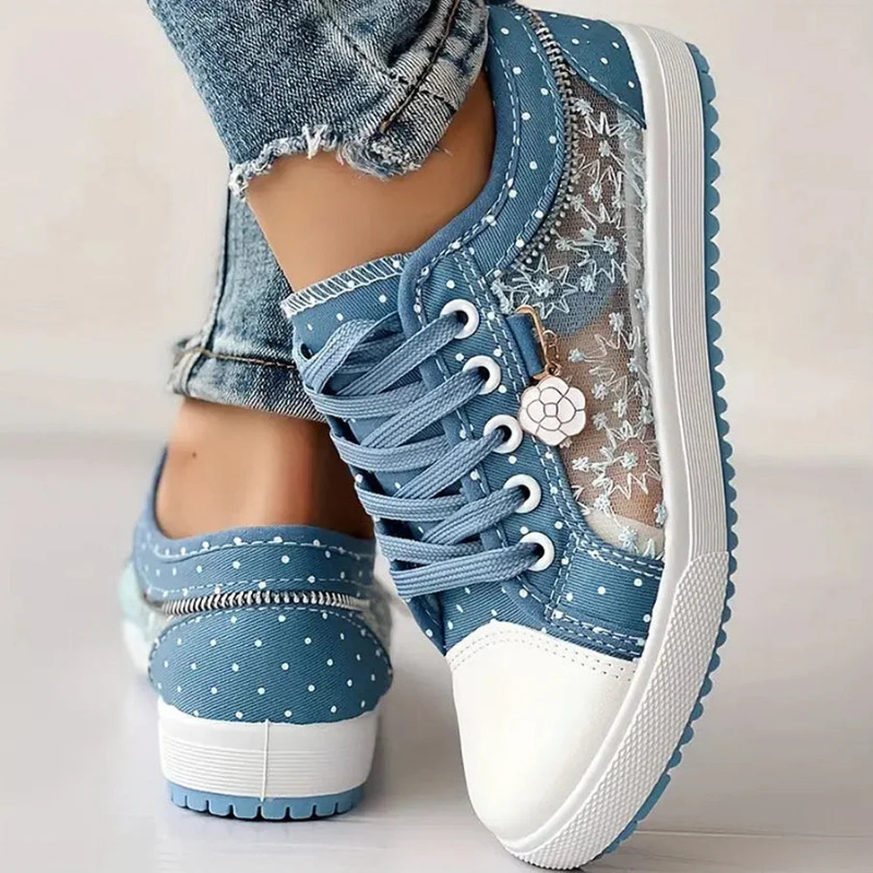 Female model showing comfortable casual sneakers on a plain backdrop.
