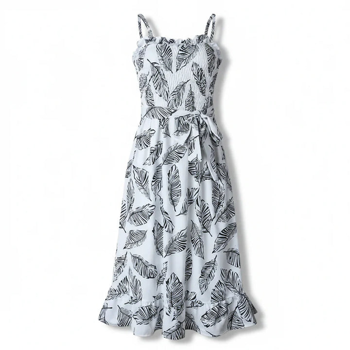 Sleeveless dress with leaf patterns and ruffle details against a plain background.