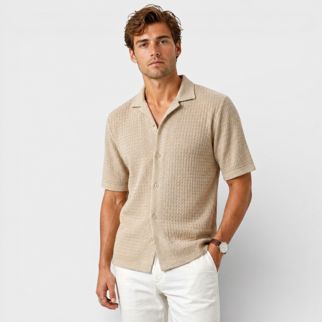 Male model wearing a light knit summer shirt against a plain background.