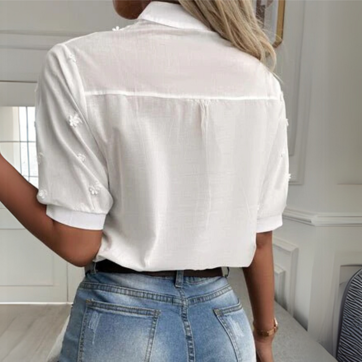Timeless women’s blouse styled on a wearer against a plain background, back view