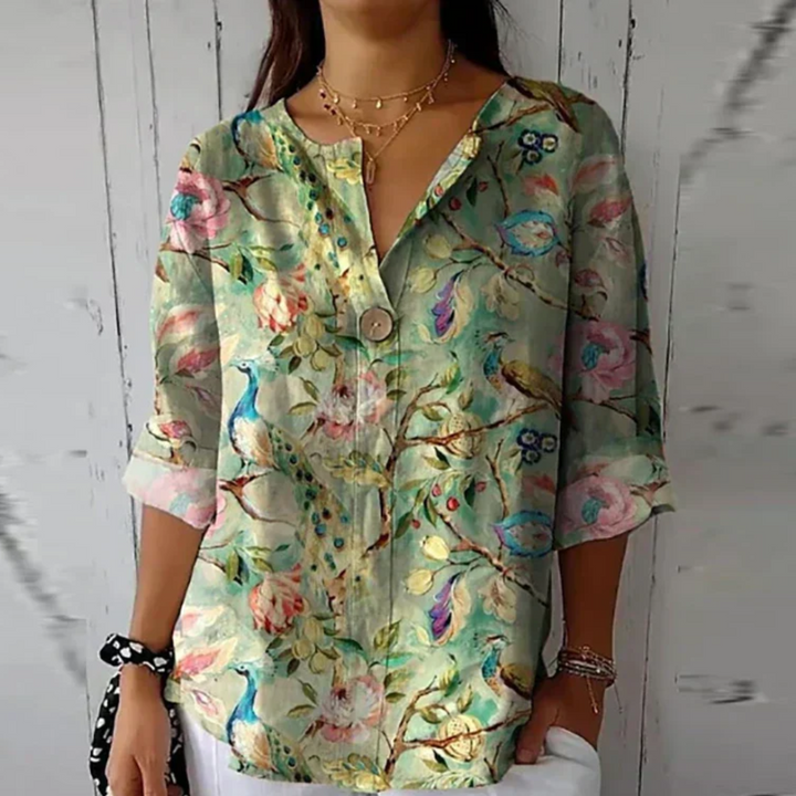Floral everyday top with model on a plain background, styled simply.