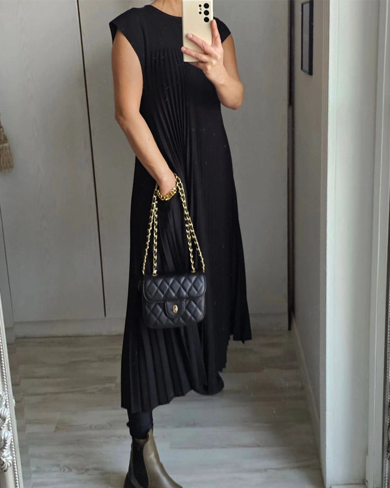 Female model showcasing a graceful pleated dress with a long silhouette.