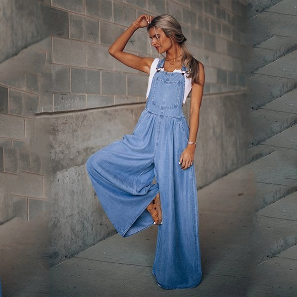 Casual denim jumpsuit with adjustable straps and bib front on a plain background.
