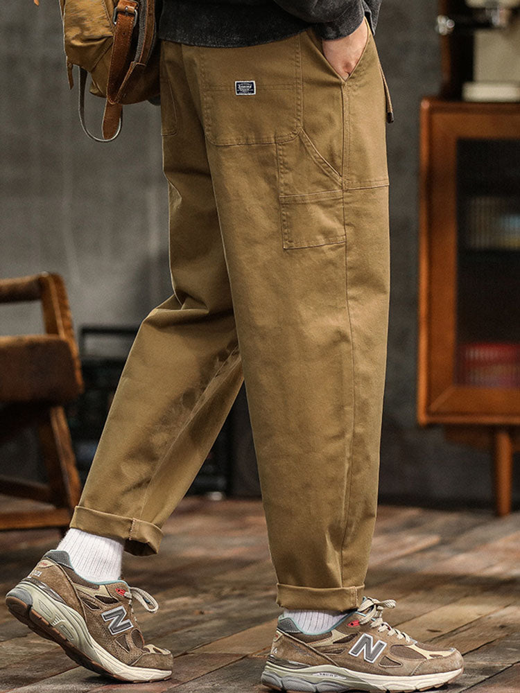 Male model wearing wide-leg utility trousers with distinctive pocket detailing on a plain background.