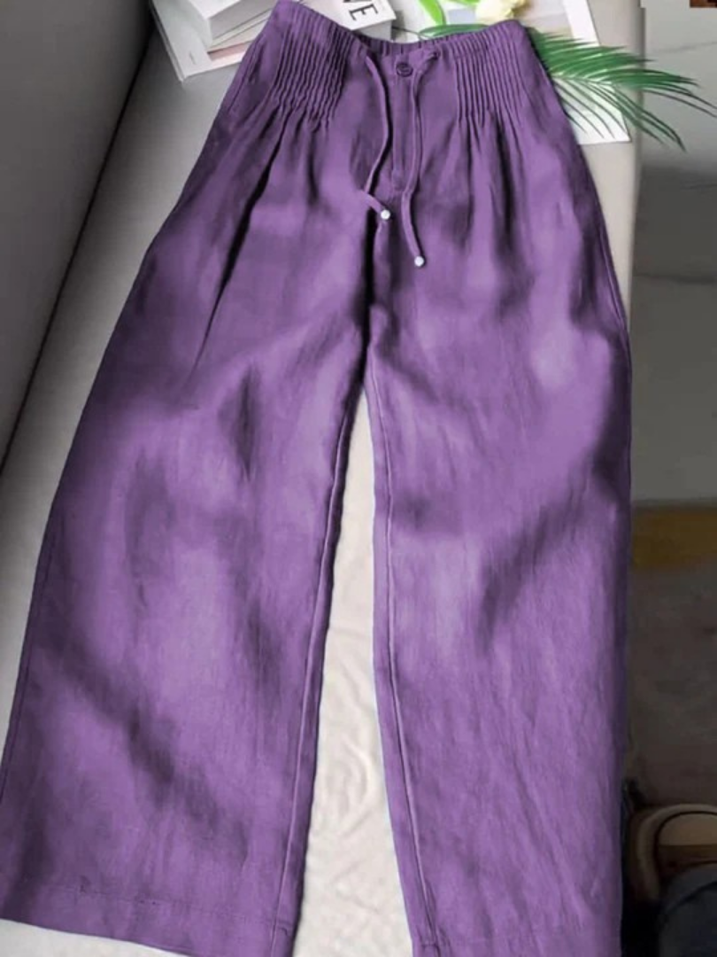 Wide-leg pants styled on a plain background with a smooth waistband and loose fit.