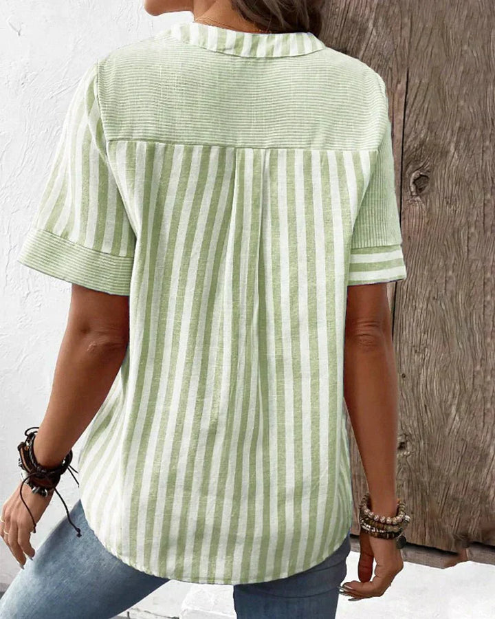 Casual elegant striped blouse styled with a wearer on a plain background, back view