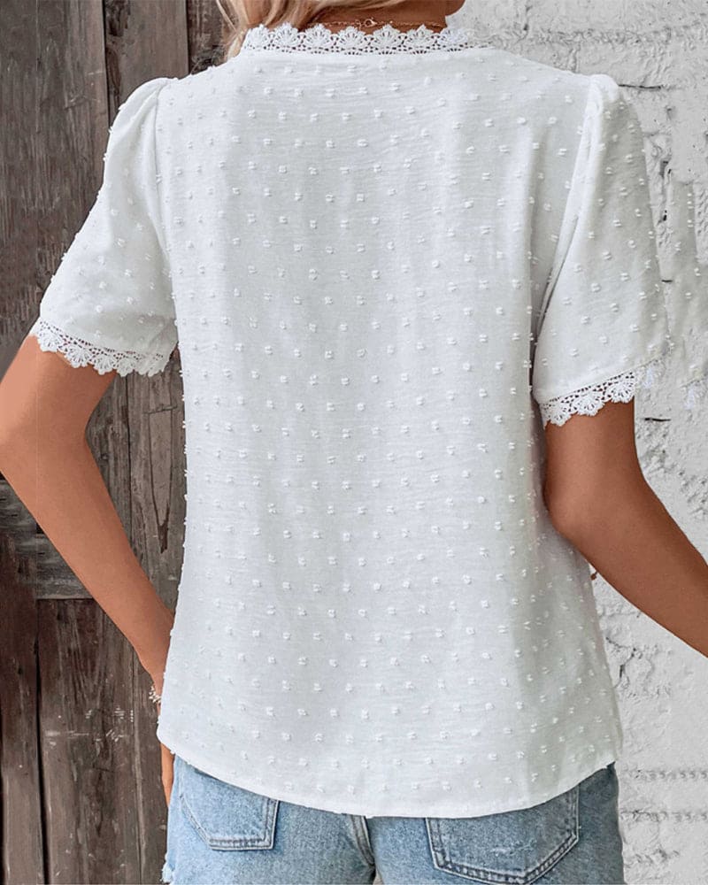 Stylish blouse shown on model against nature backdrop.