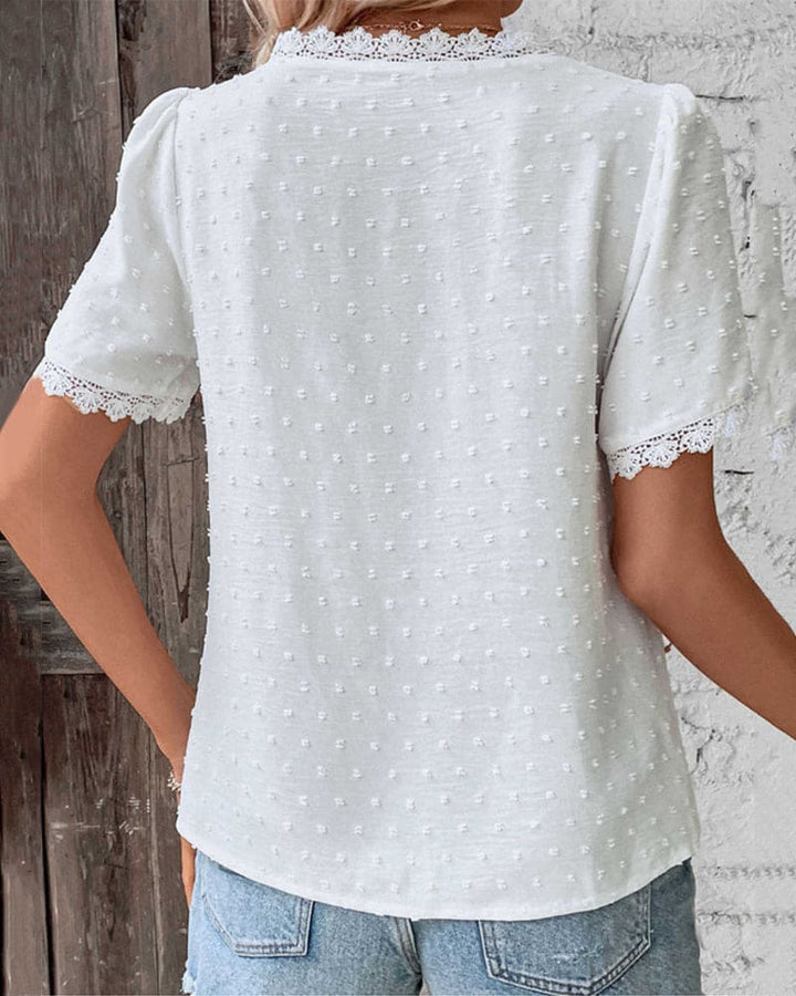 Stylish blouse shown on model against nature backdrop.