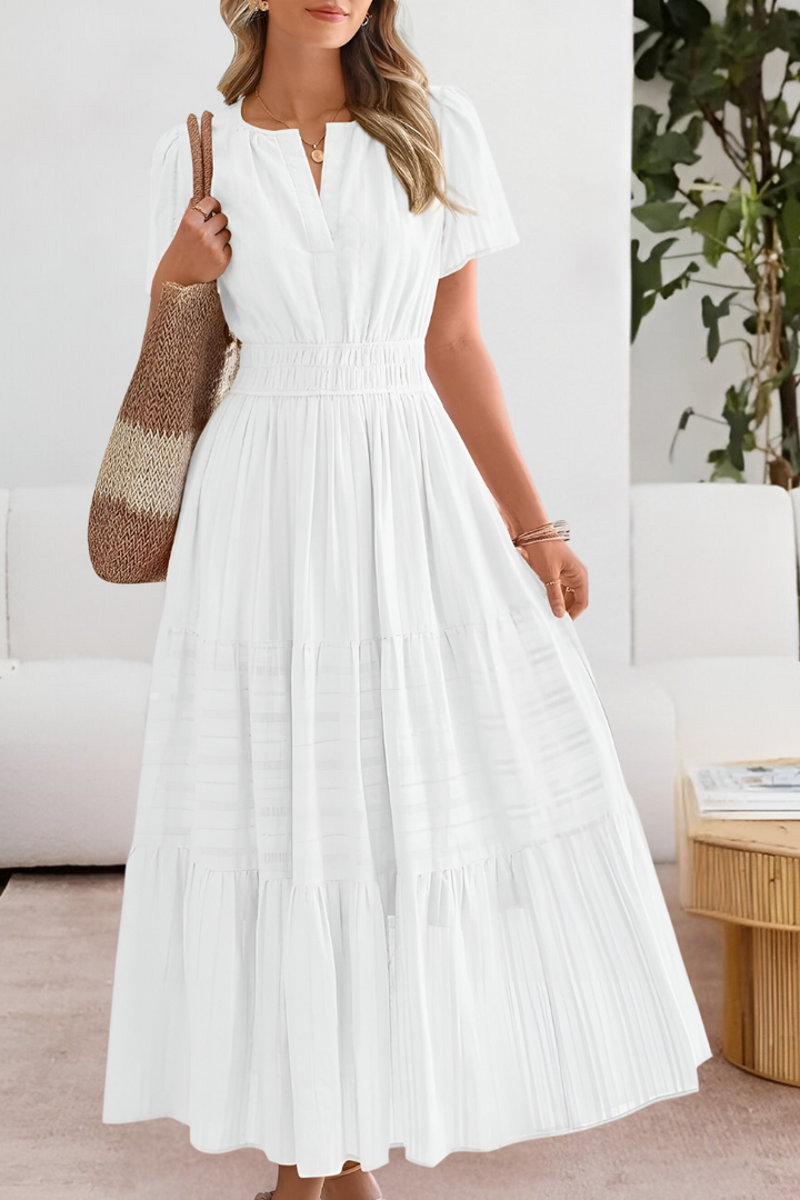 Relaxed fit summer dress with elegant flow shown on a plain background.