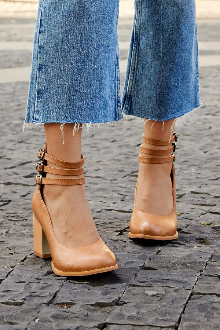 Plain background image of a foot wearing a secure strap heel sandal.