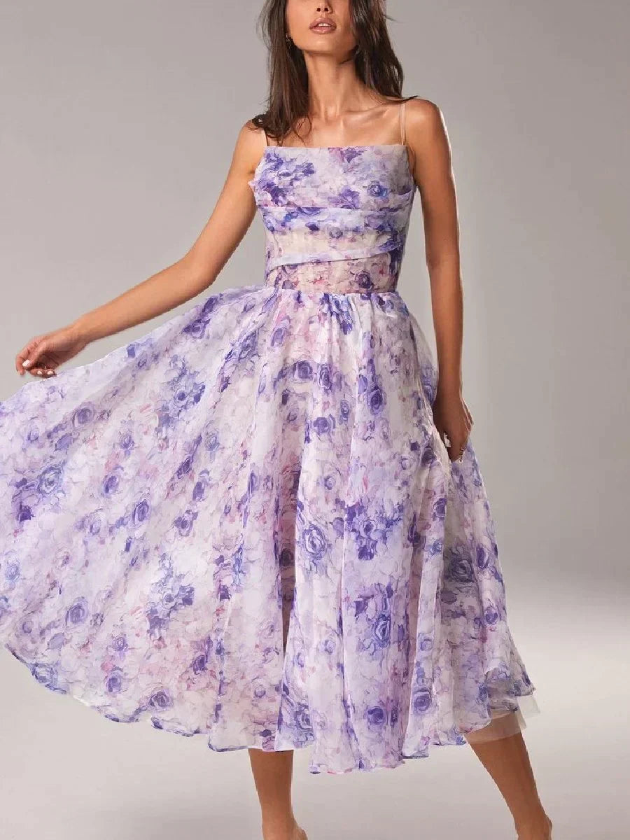 Female model in a floral print midi dress featuring a strapless neckline and elegant flared skirt on a plain background.