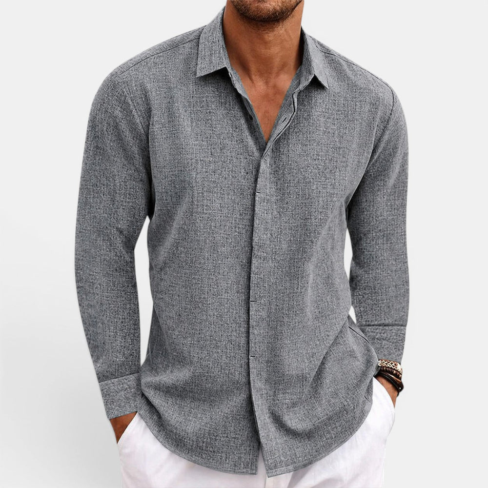  Male model showcasing a breathable button-up shirt on a plain background.