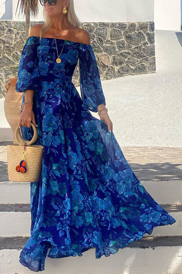 Woman wearing a floral off-shoulder maxi dress on a plain background.