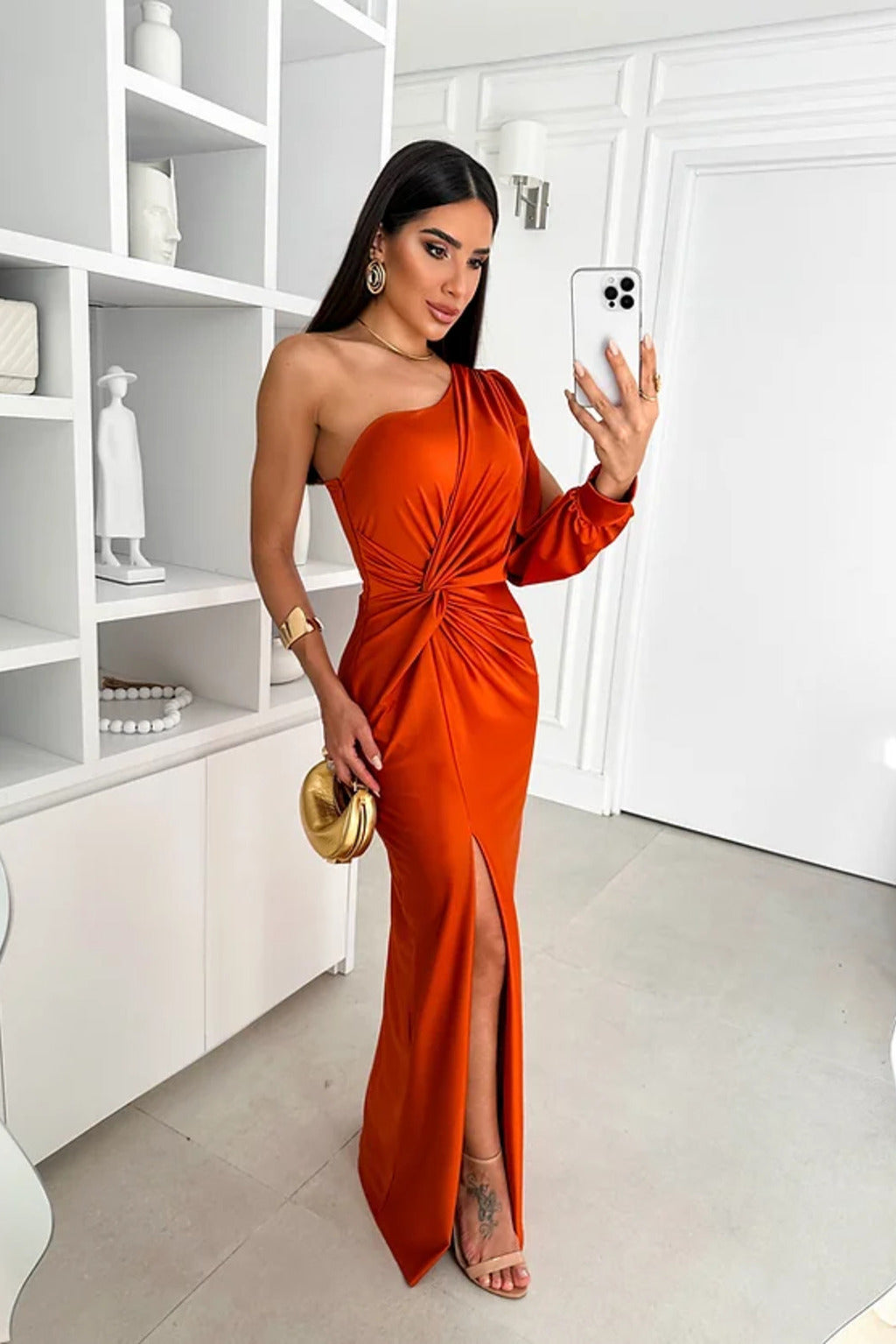 Model in a soft flowing long dress with a plain backdrop.