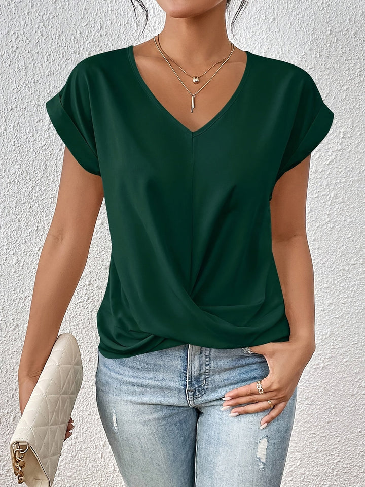 Woman standing straight with green top clutch in hand neutral gray background scene
