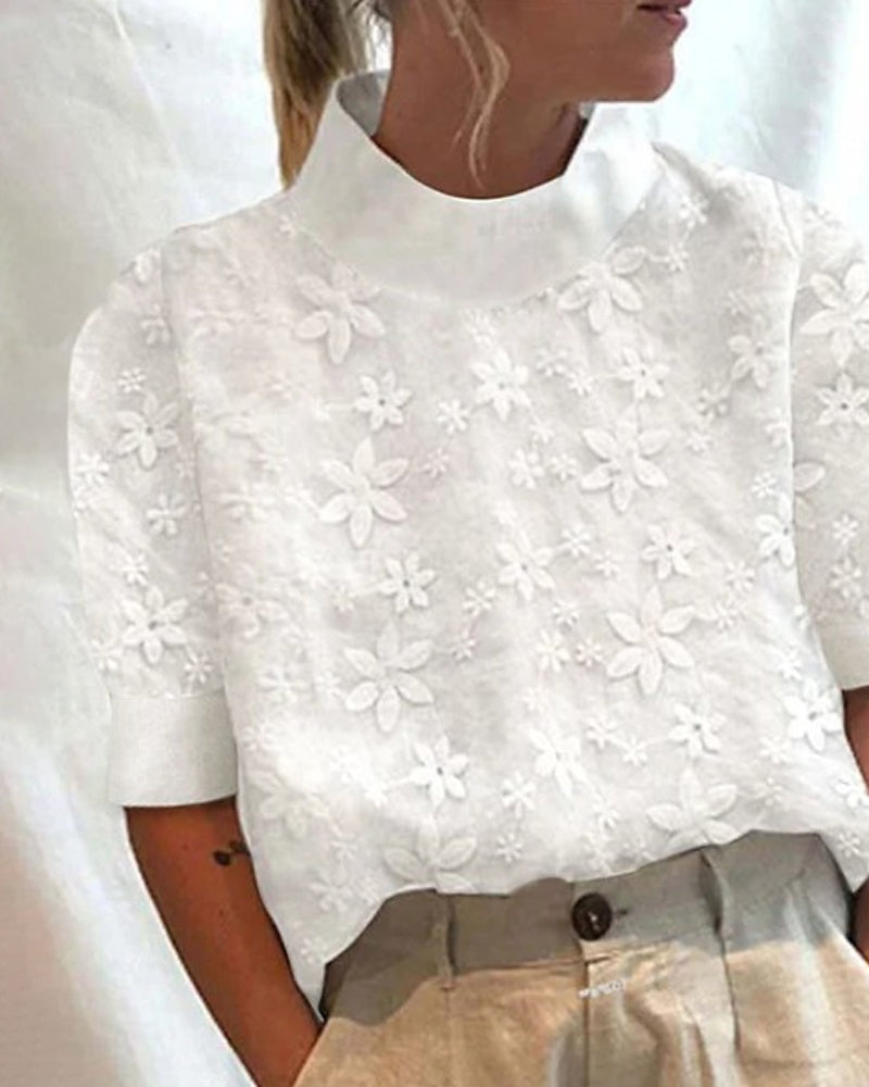 Elegant embroidered women’s blouse displayed on a clean background with a refined stand-up collar.