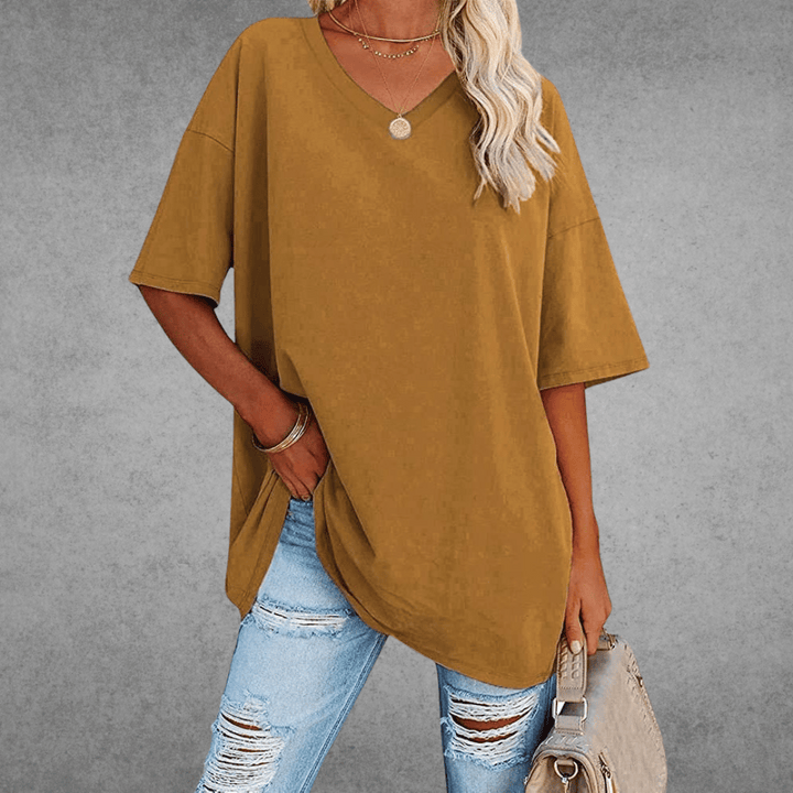 Everyday loose V-neck shirt styled with bag, gray background.