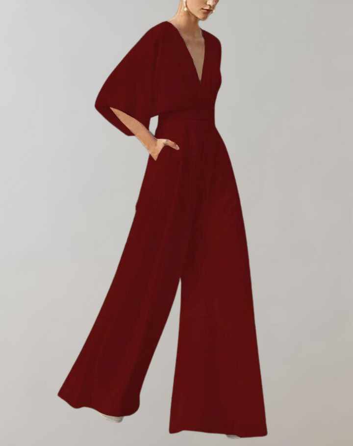 Woman wearing a flowing kimono sleeve jumpsuit styled for an evening event.