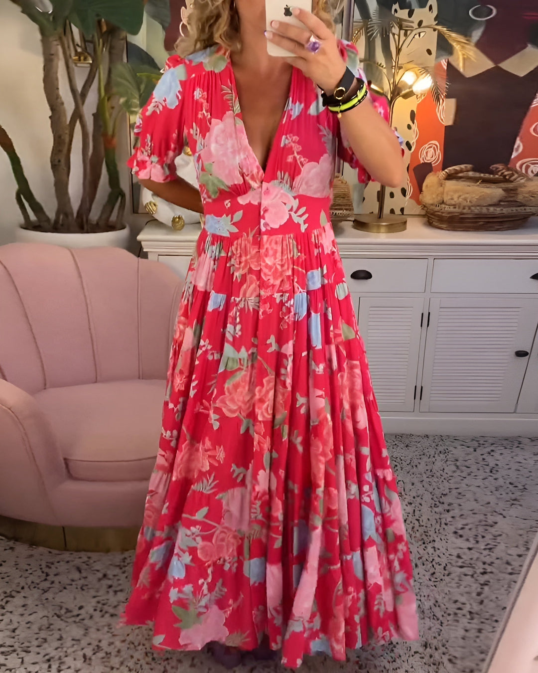 Woman wearing a flowing floral V-neck dress outdoors.