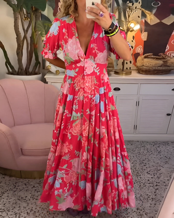Woman wearing a flowing floral V-neck dress outdoors.
