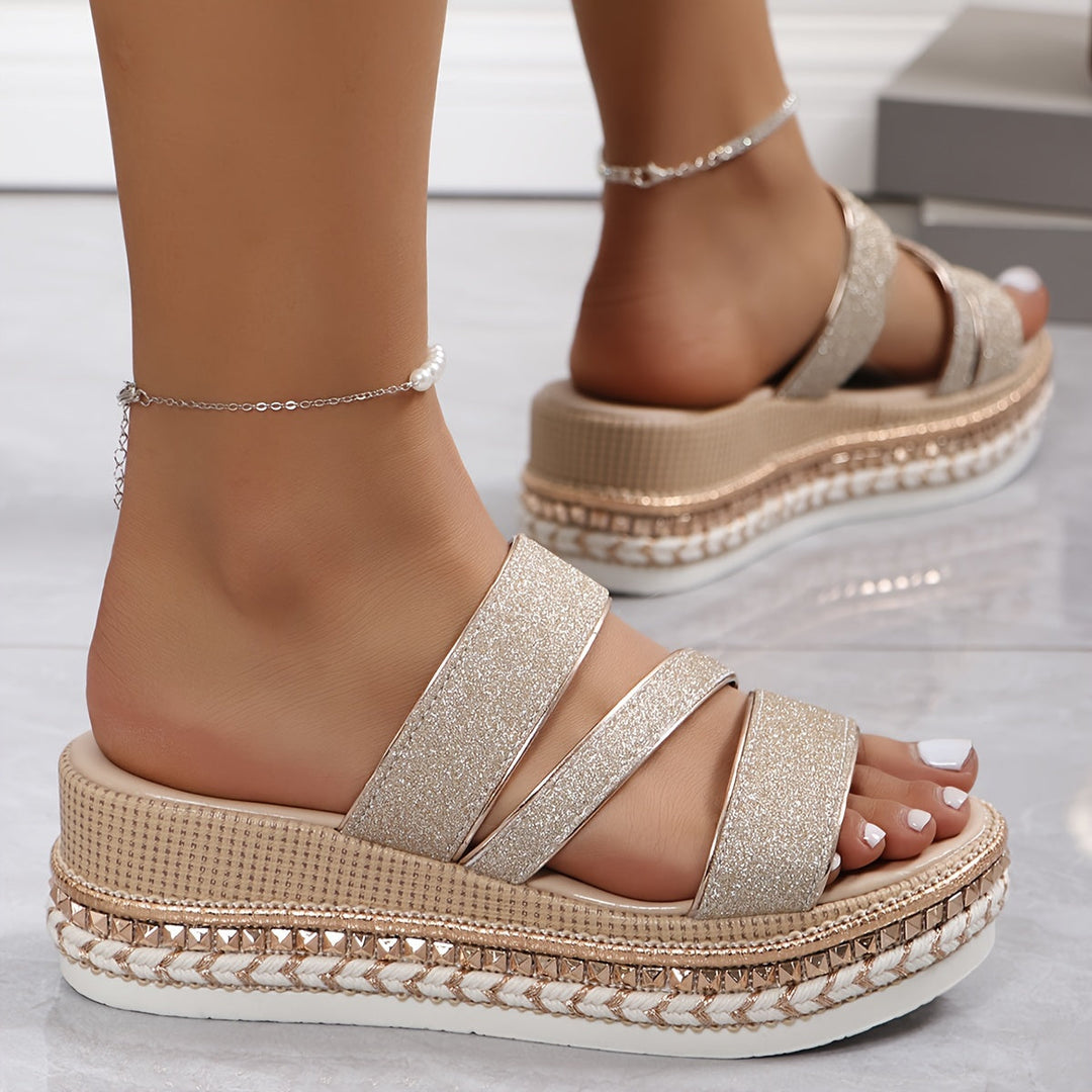 Model wearing elegant open toe sandals on a plain background.