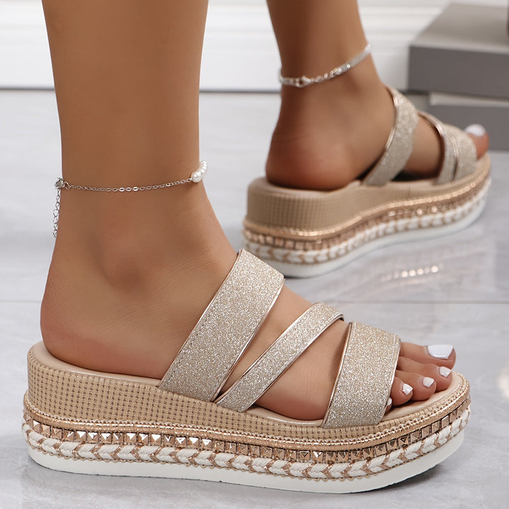Model wearing elegant open toe sandals on a plain background.