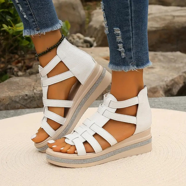 Woman wearing lightweight summer sandals with adjustable straps on a plain background.