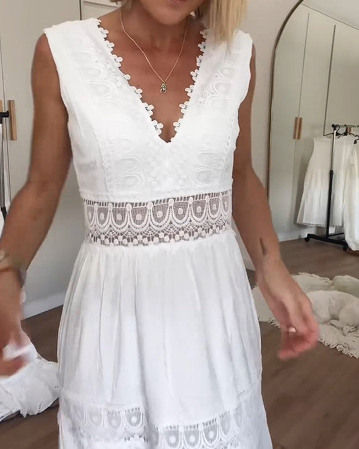 Woman standing in a relaxed boho dress with soft drape on a plain background.