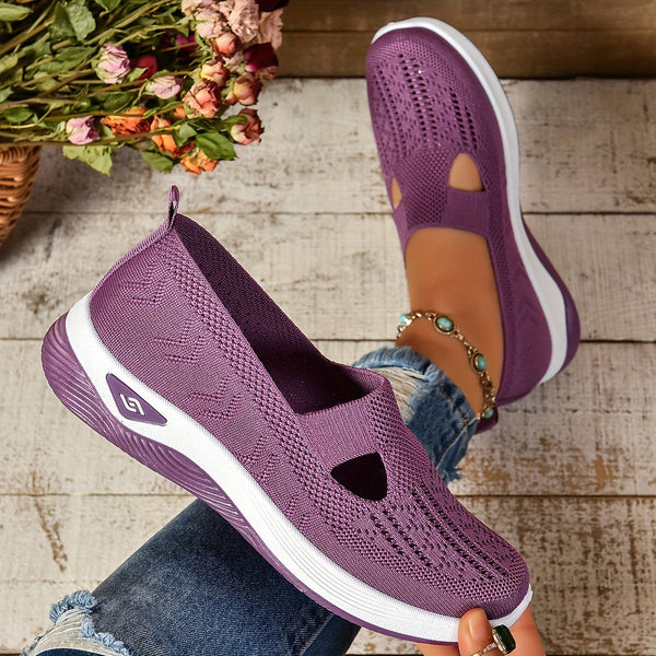 Woman standing in breathable everyday shoes against a plain background.