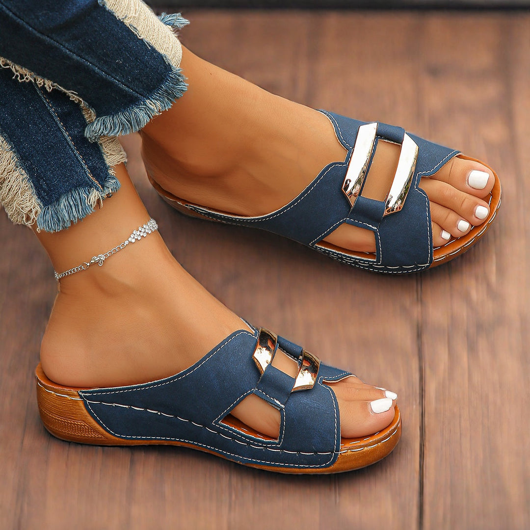 Woman foot model wearing cushioned adjustable buckle sandals on a plain background.