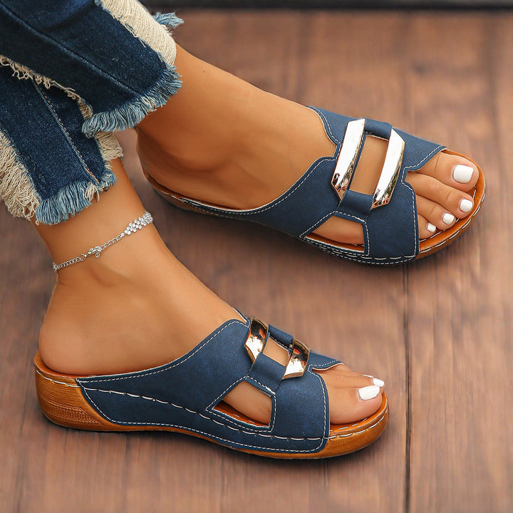 Woman foot model wearing cushioned adjustable buckle sandals on a plain background.