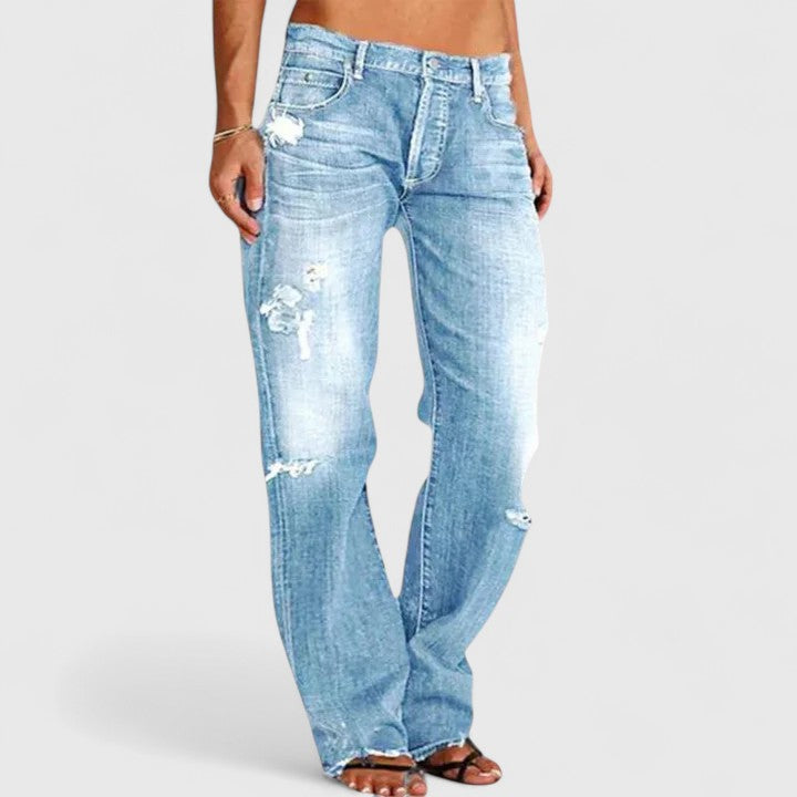 Model wearing low-rise flared jeans with vintage-inspired denim details on a clean background.