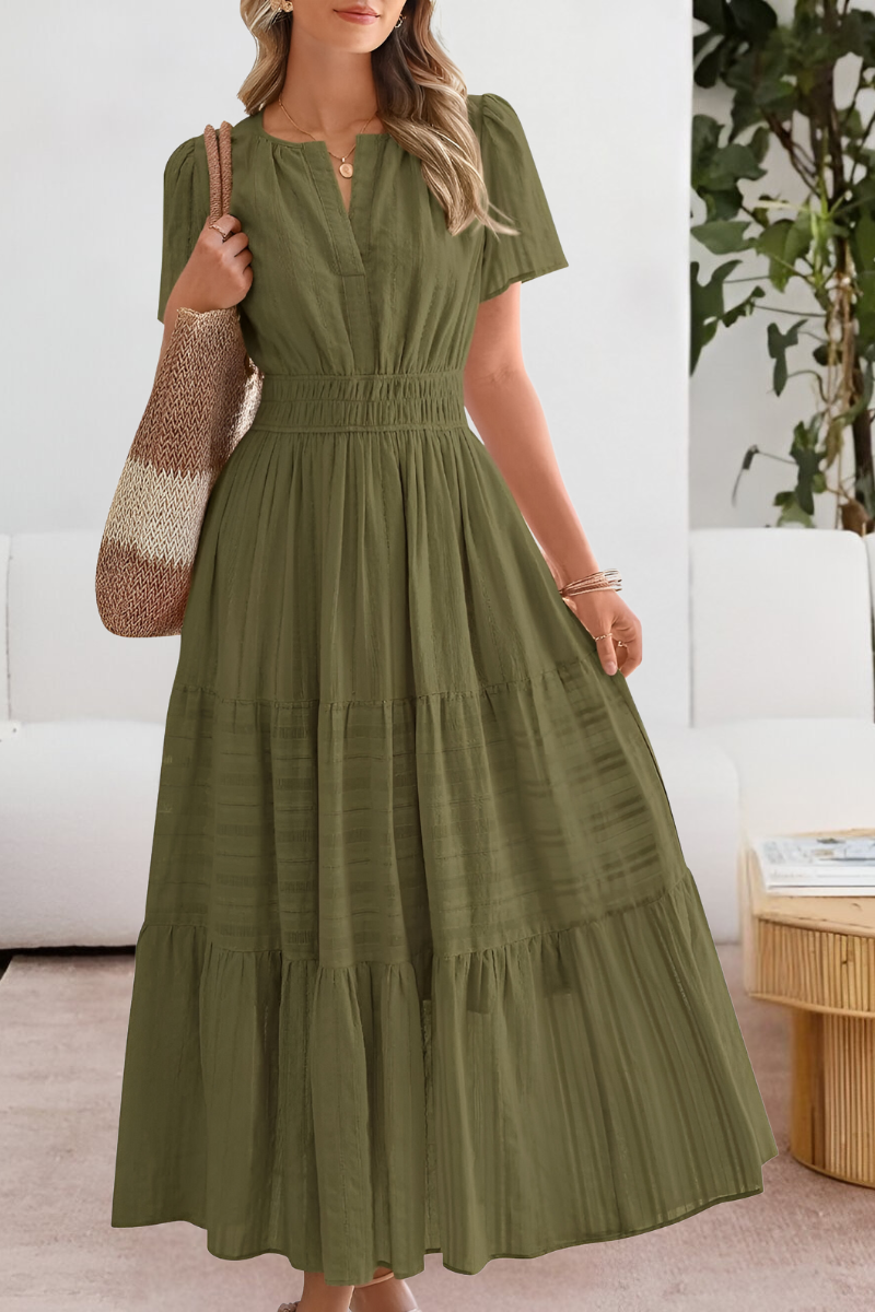Female model in a casual boho dress with flowing movement on a plain background.