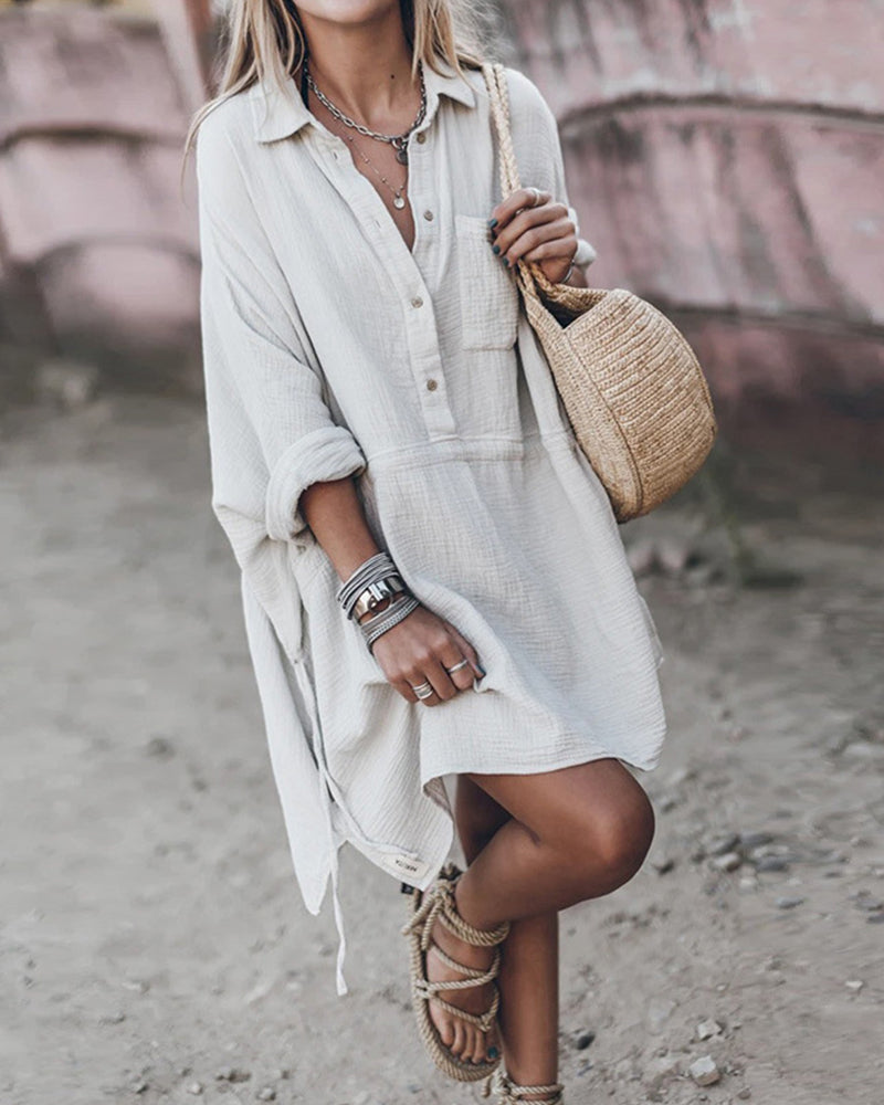Female model wearing a collared flowy shirt dress against a plain background.