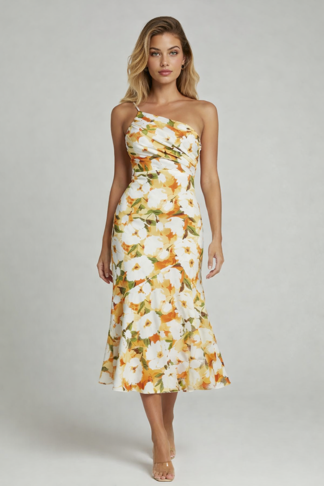 Female model in a one-shoulder floral dress with fitted waist on a plain background.