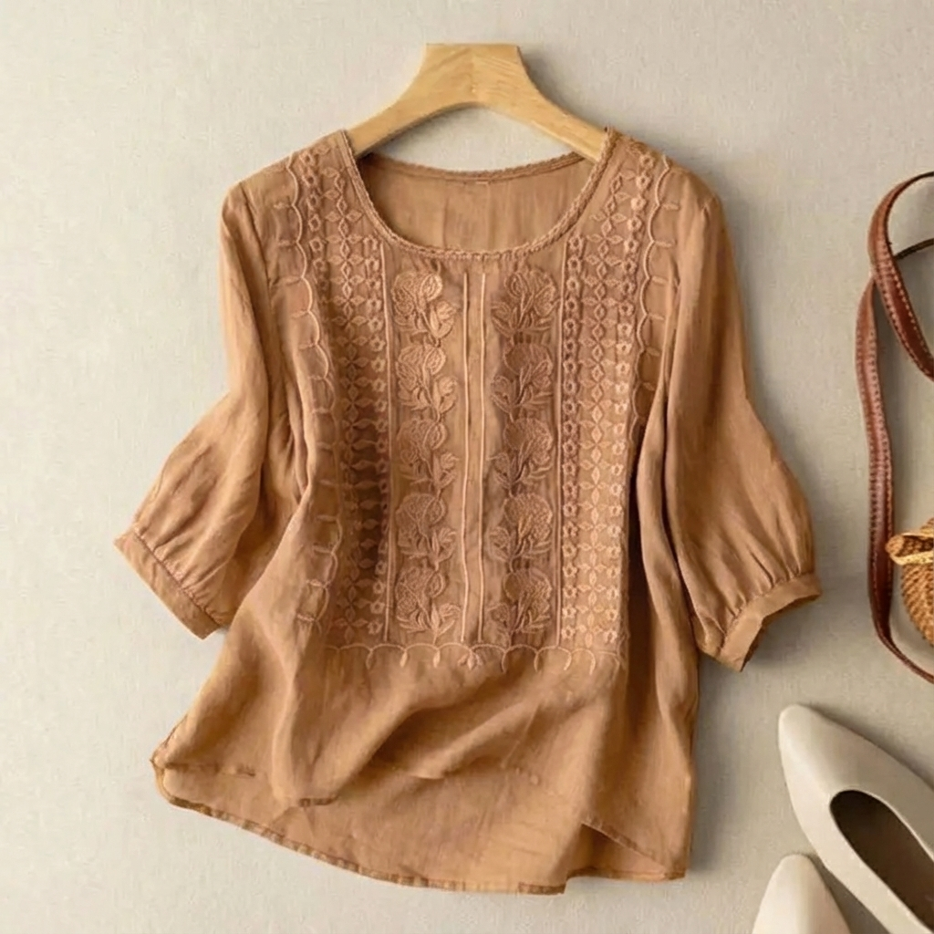 Relaxed fit women’s blouse with delicate stitching on plain background.