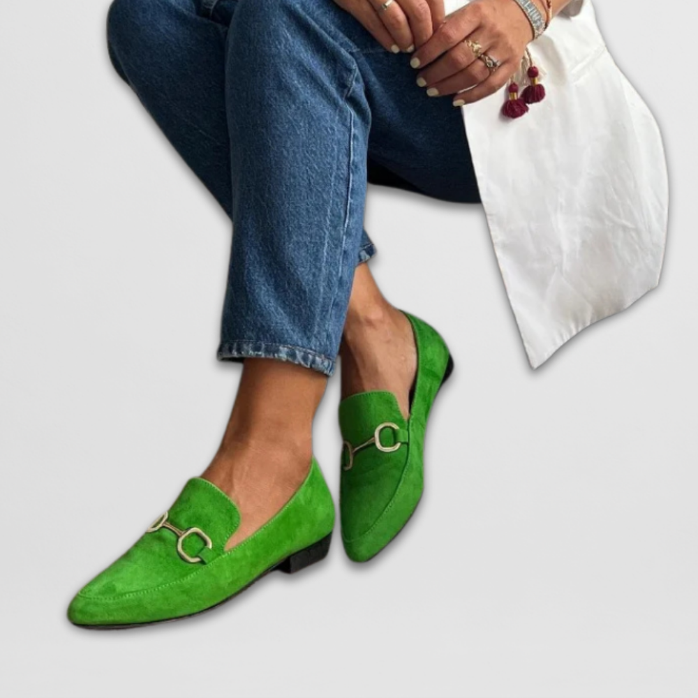 Female model wearing vibrant slip-on moccasins against a plain background.
