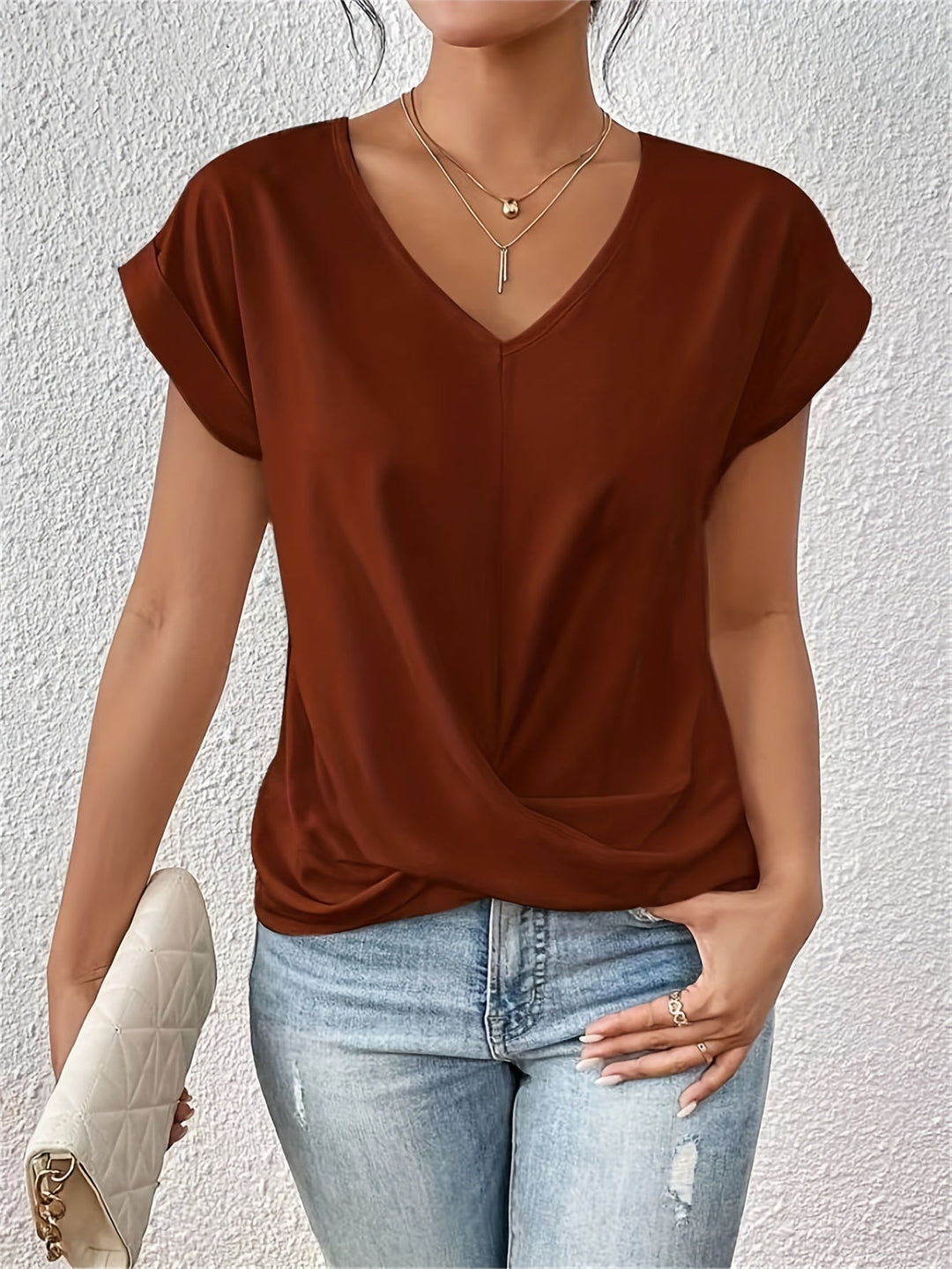 Model holding clutch looking forward minimal gray background setting
