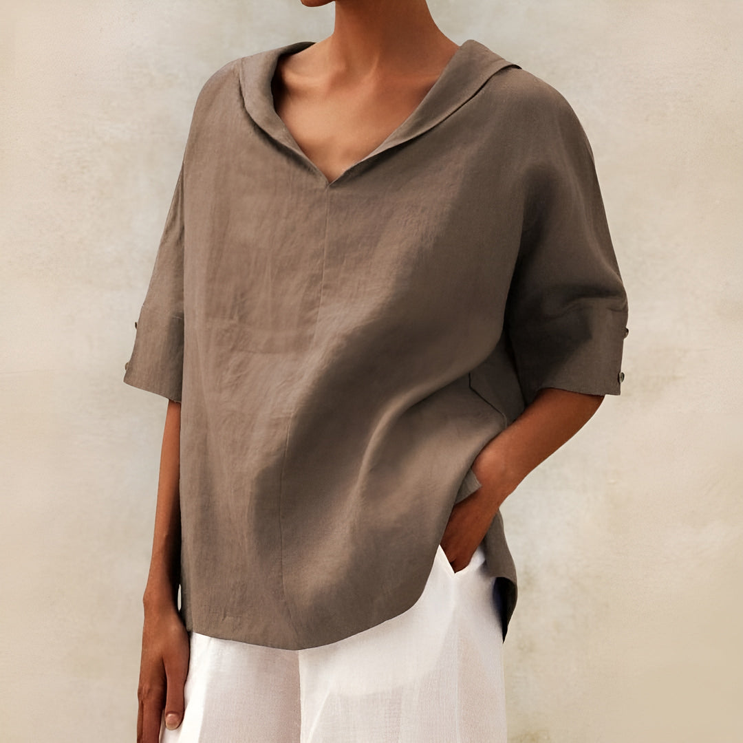 Relaxed fit blouse shown on a clean background with soft texture and timeless feminine detail.