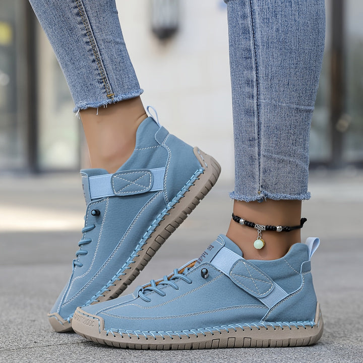 Woman modeling strap closure sneakers with a clean everyday look.